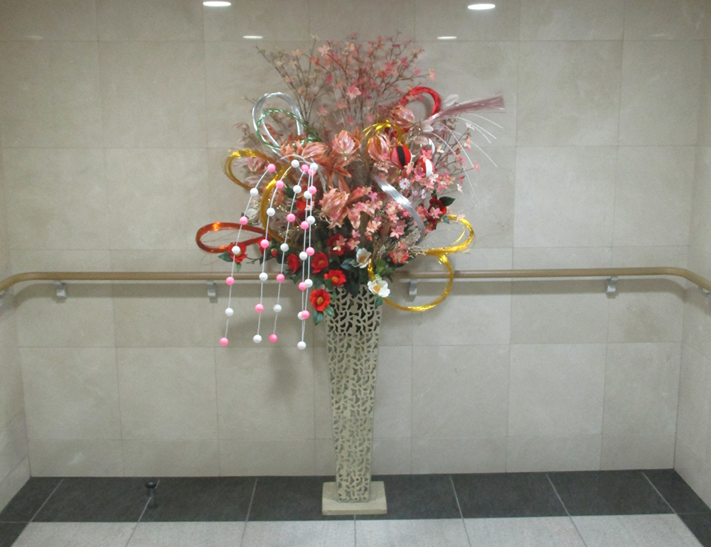 水引や舞玉などお正月飾りのついた華やかな大型スタンド花